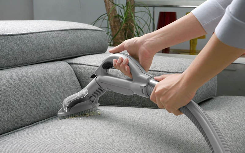 Hút bụi ghế sofa trước khi giặt